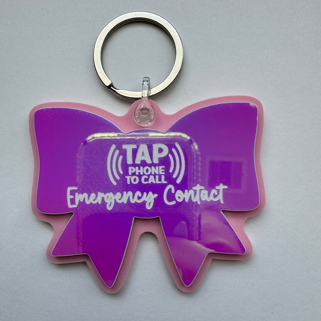 Purple bow-shaped keychain with 'Tap Phone for Call Emergency Contact' text on a white background